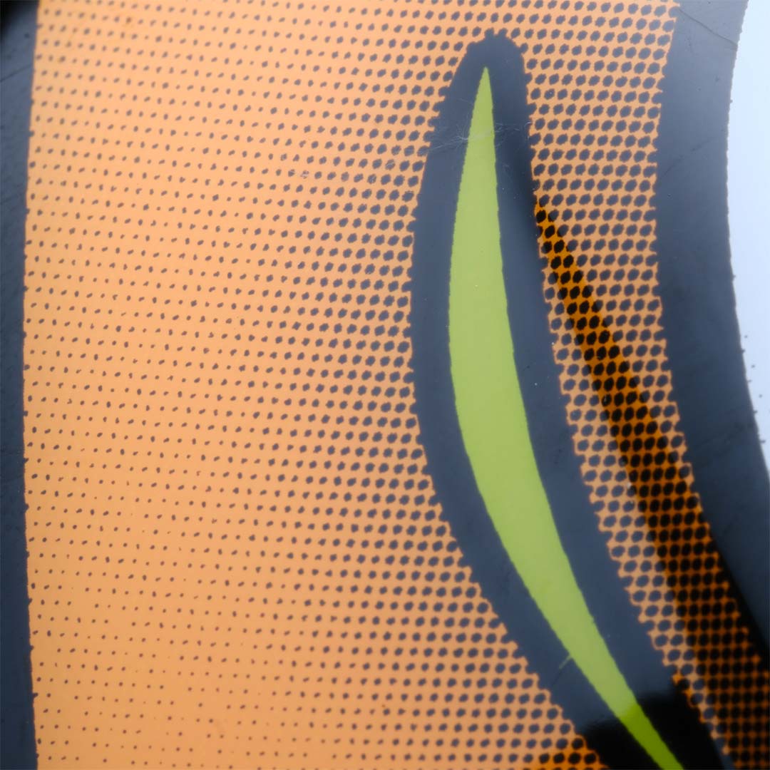 Close-up of an orange surface with a green leaf design.