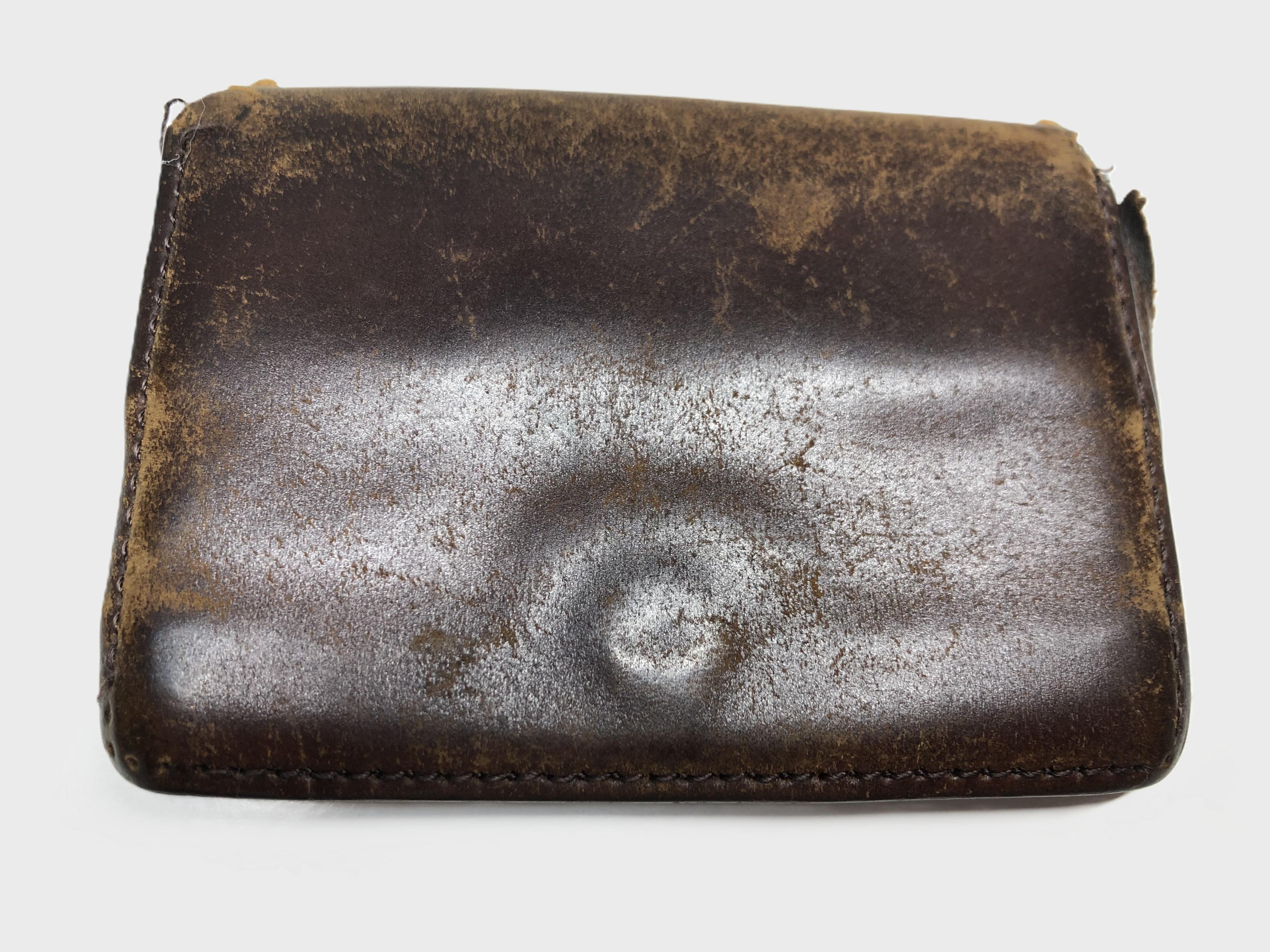 Worn brown leather wallet with visible creases and scratches.