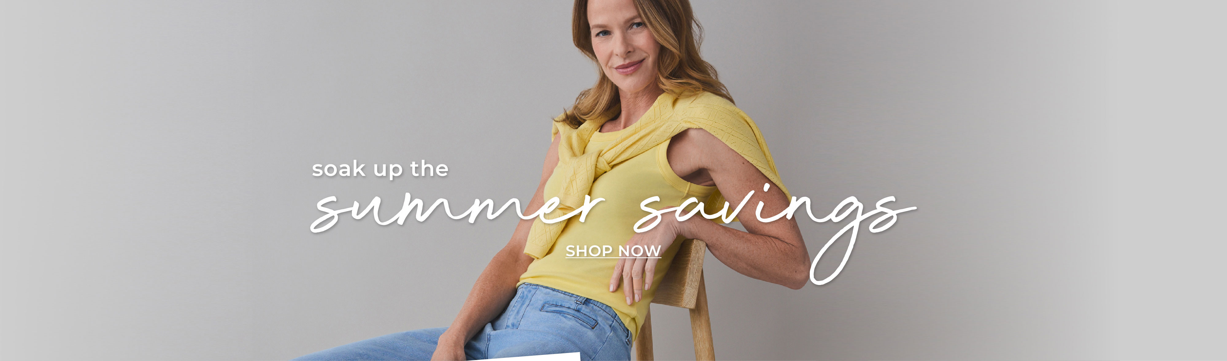 Woman sitting in yellow top and sweater with text overlay, soak up the summer savings.