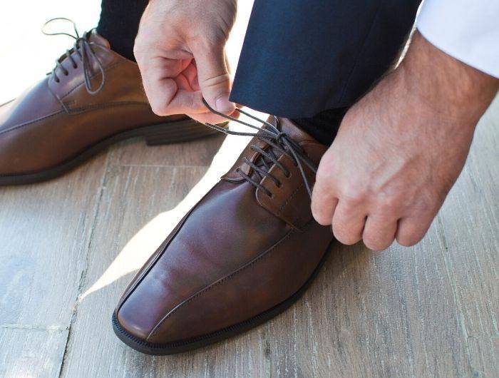 Man tying brown dress shoes