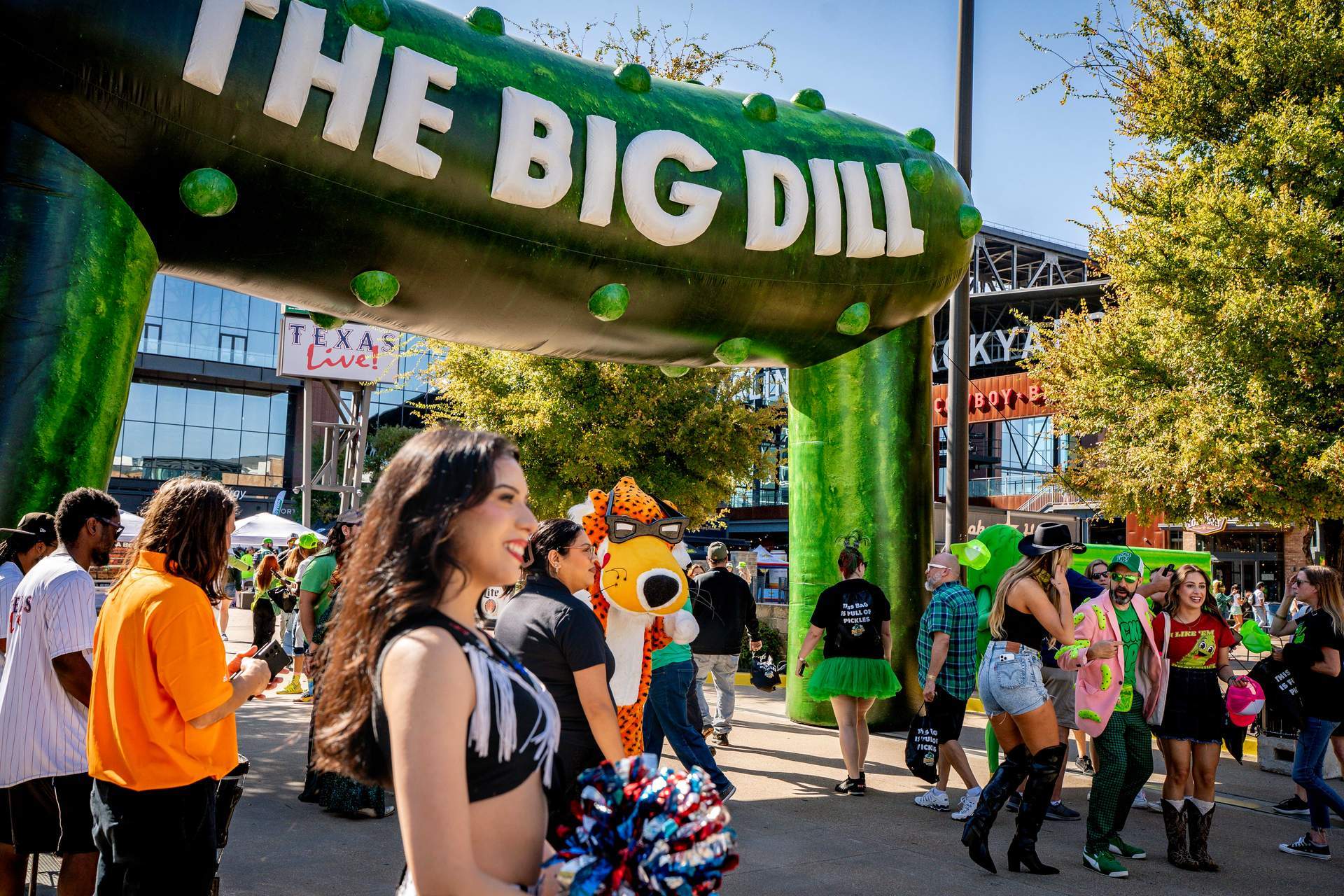 Festival guests gather under The Big Dill 30-foot inflatable pickle arch with the Cheetos mascot at The Big Dill pickle festival, Globe Life Field and Texas Live!, Arlington Texas 2025