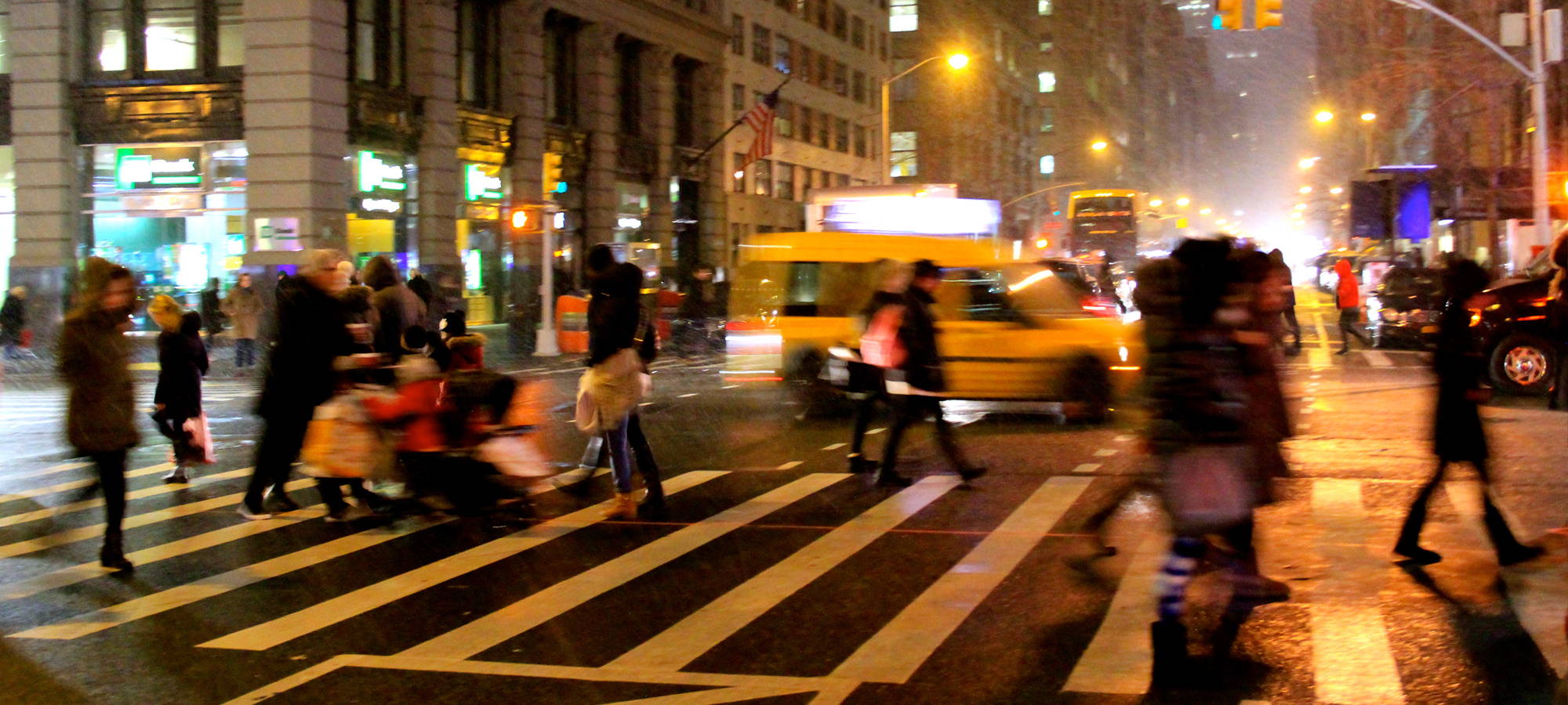 Pedestrians using a crosswalk at night.