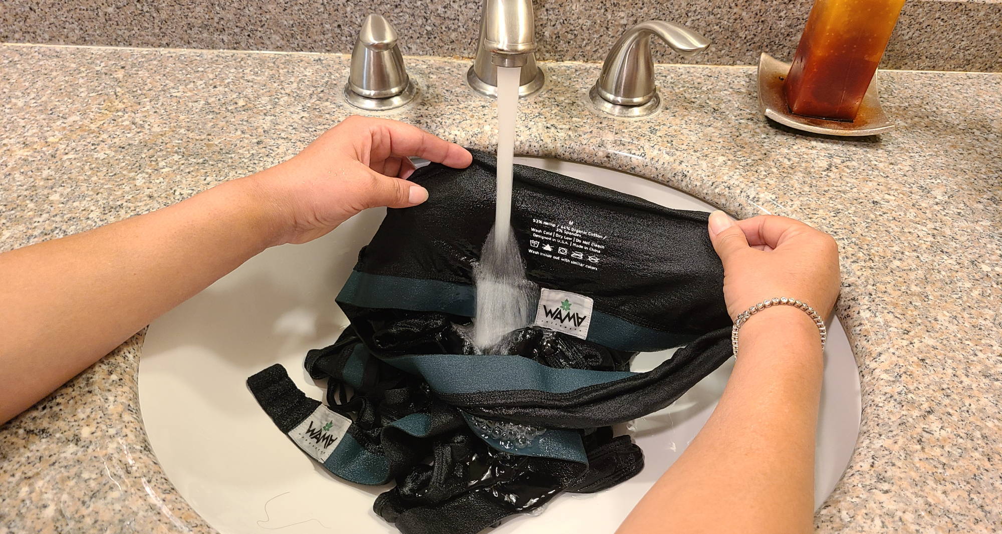 Woman showing how to hand wash underwear underwear in the sink.