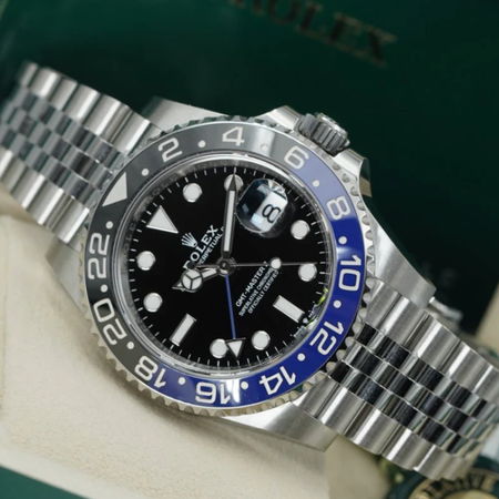A Rolex GMT Master II watch with a black dial and blue bezel.