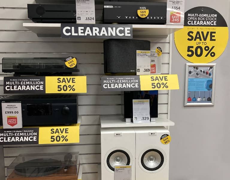 Electronics on clearance with 50% off signs displayed on shelves.