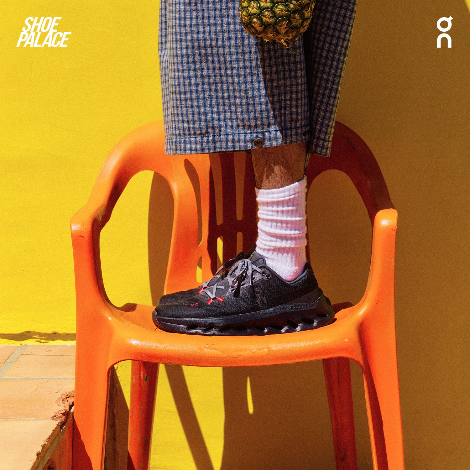 Person standing on an orange chair wearing black shoes and striped socks.