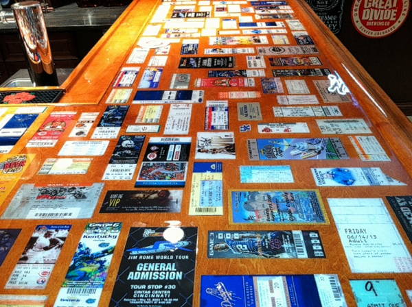 An epoxy bar top with many embedded concert tickets