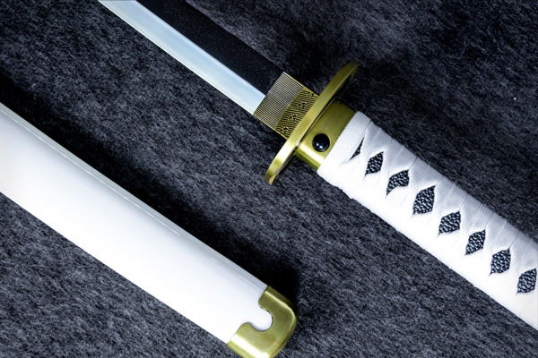 A close-up of a katana with a white handle and gold accents.