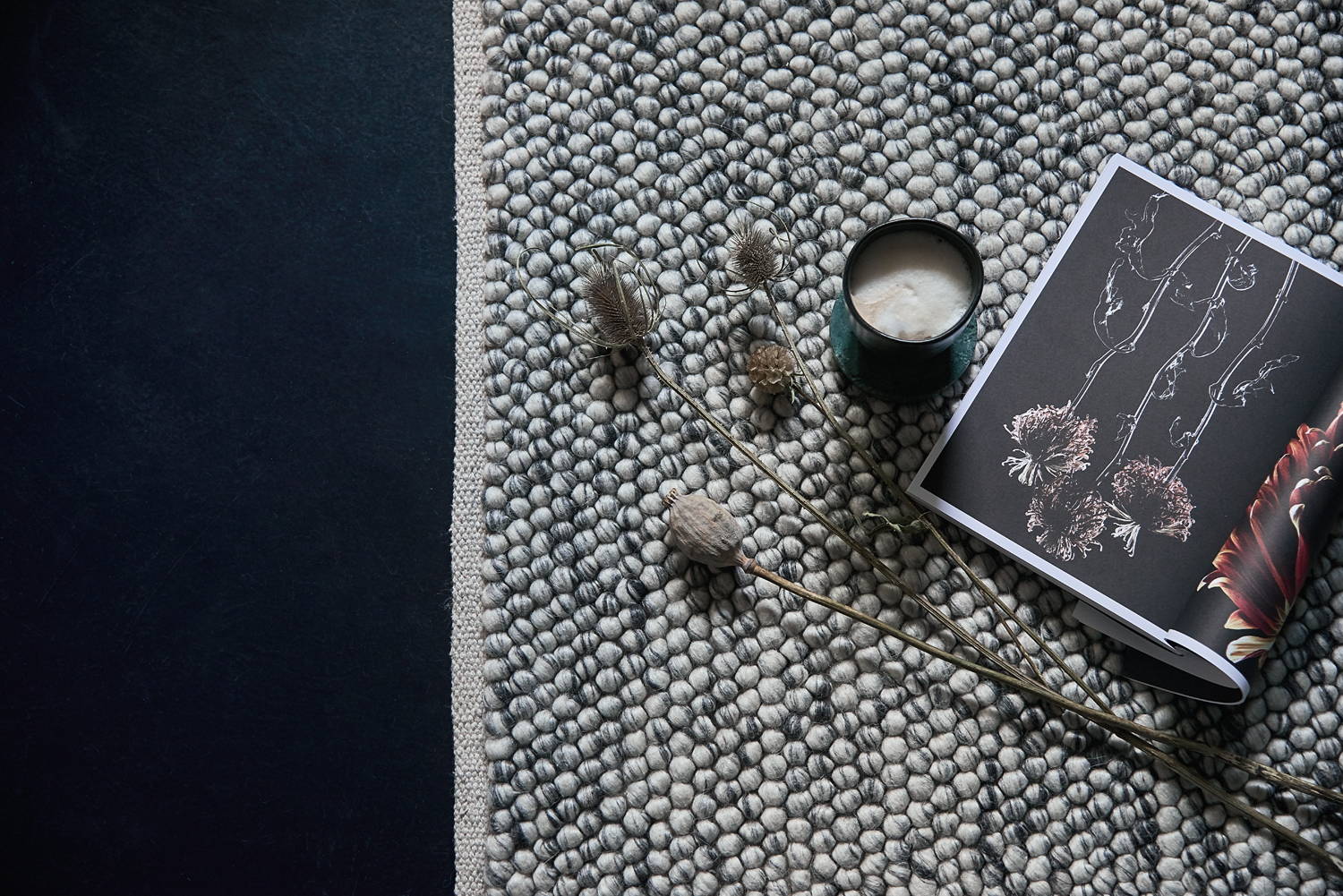 Wabi Sabi woven grey and white wool rug with wildflowers  and crockery 