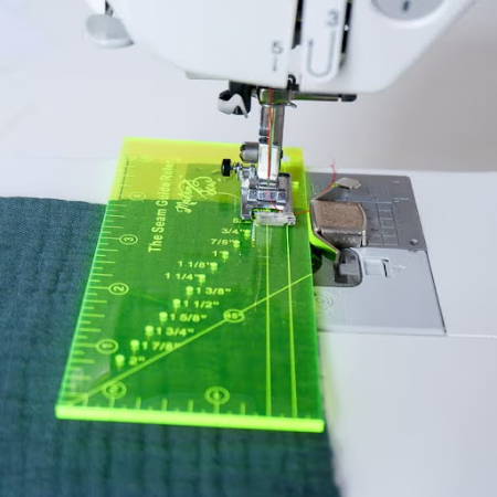A seam guide ruler on a sewing machine bed with a magnetic seam guide