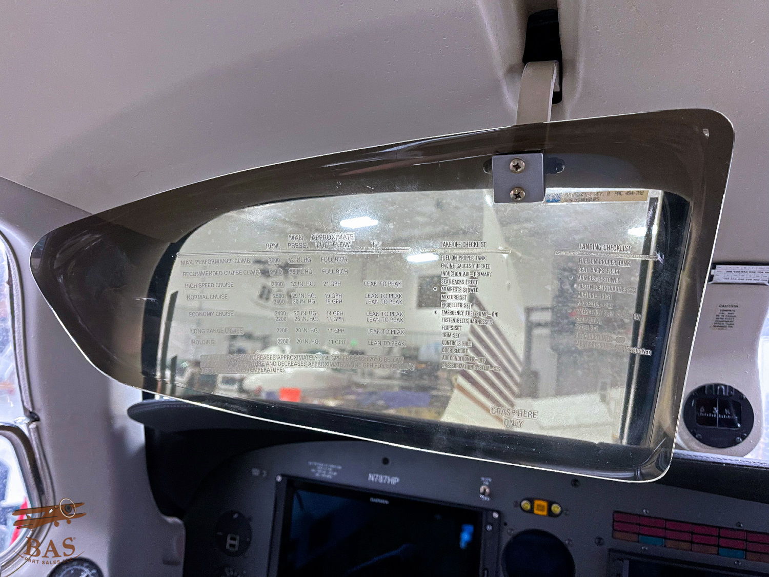 Close-up of a cockpit window with controls and interior reflections.