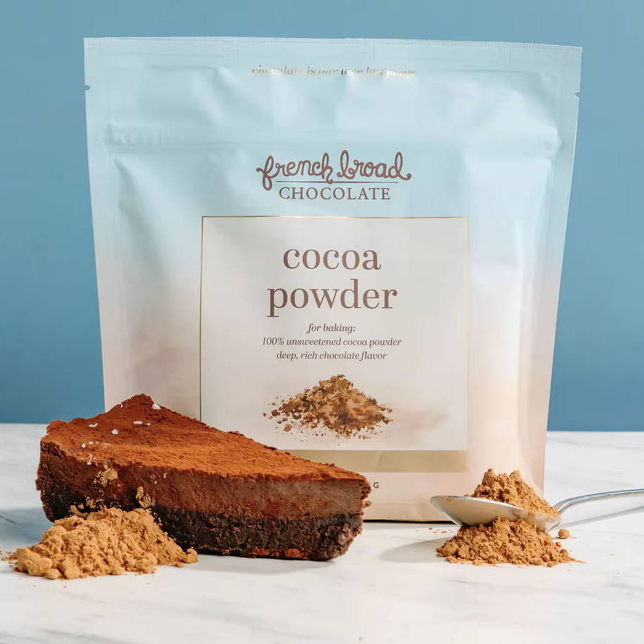 Cocoa powder package with chocolate cake and cocoa powder scattered.