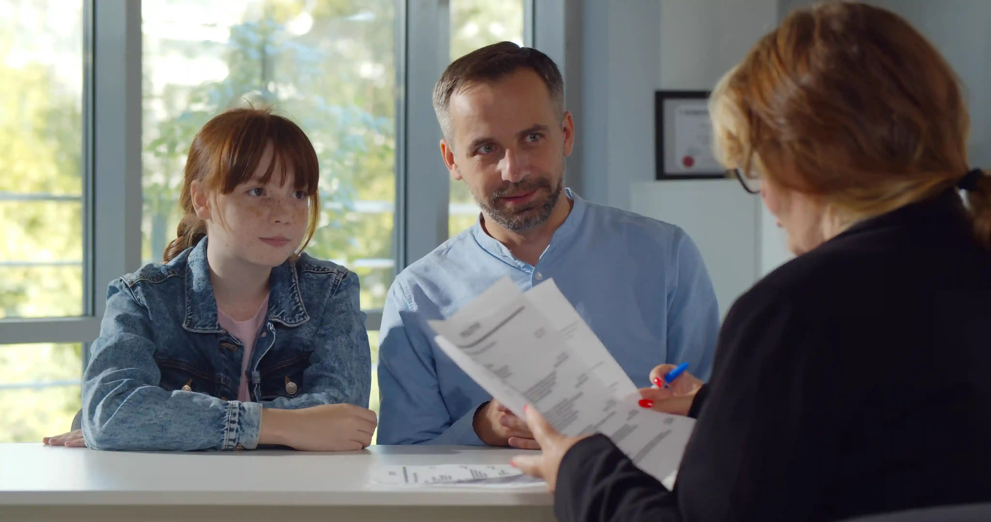 Vader en dochter die haar anafylaxieplan bespreken met de docent, het is essentieel dat school met een ernstige allergie kan omgaan en weet hoe ze moeten handelen