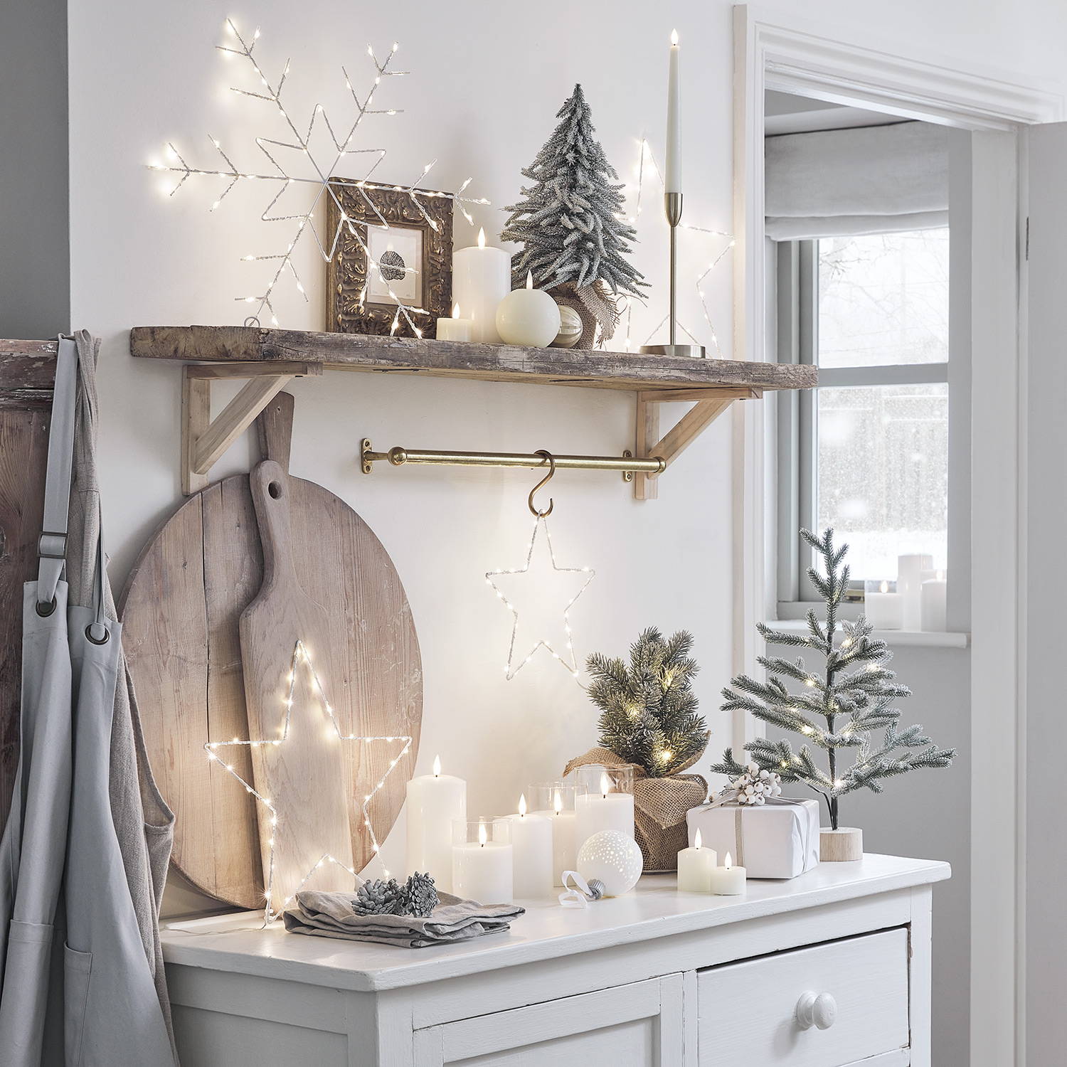 A collection of star lights, LED candles and mini Christmas trees on a kitchen worktop