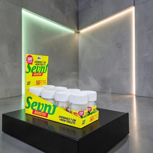 Display of Sevn brand products on a black pedestal with modern lighting.