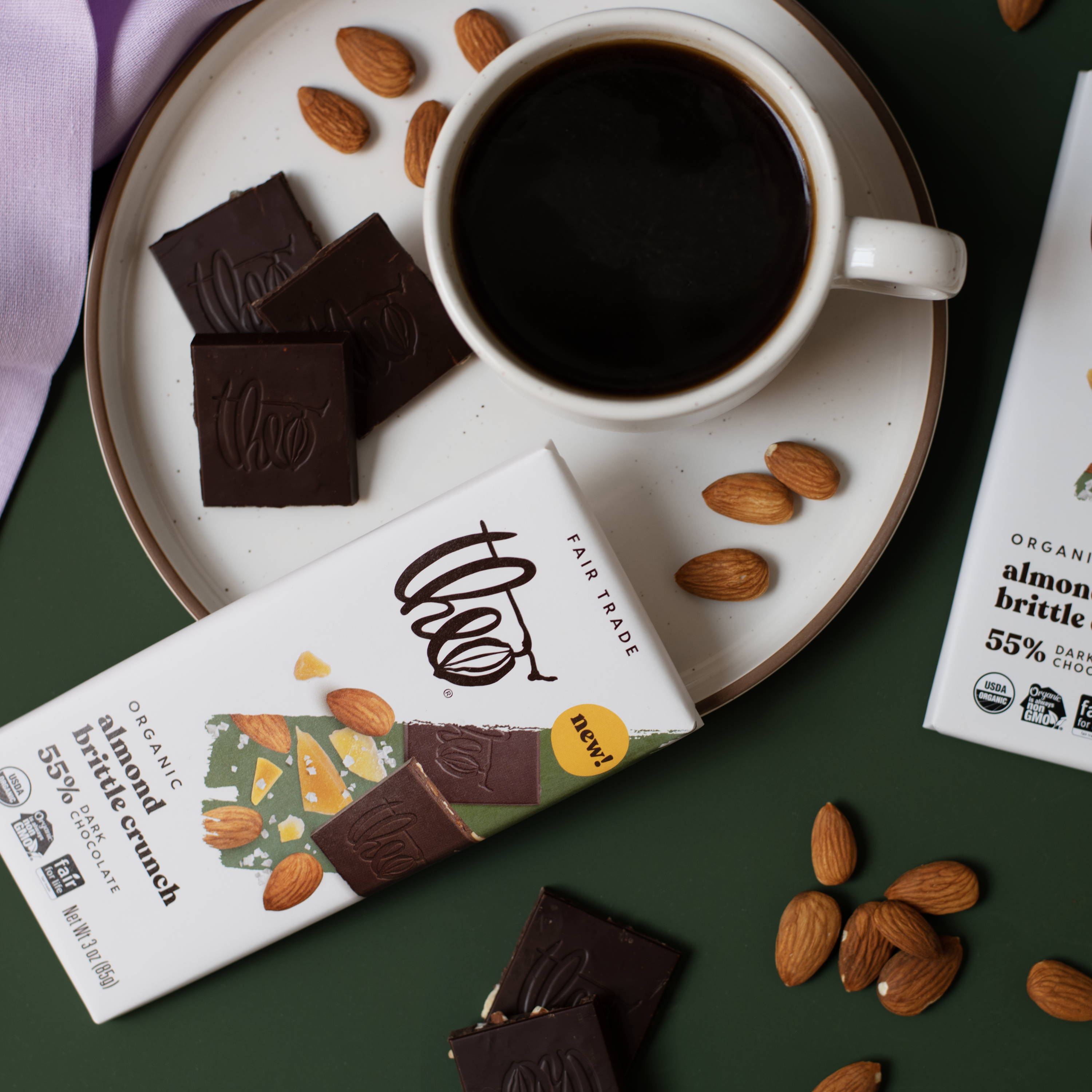 Almond Brittle Crunch bar with coffee cup on green background