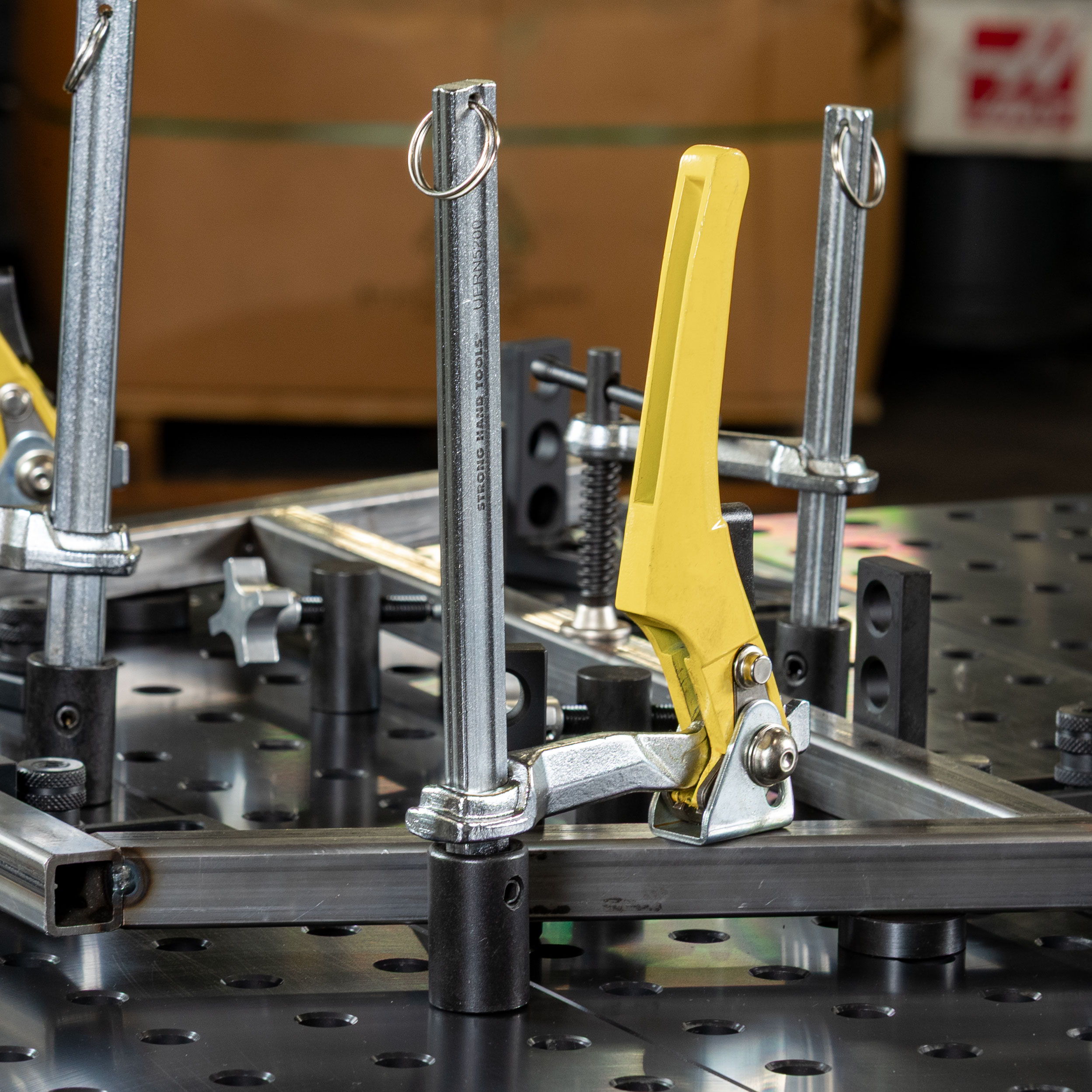 Metal fixture with clamps and adjustable components on a work surface.