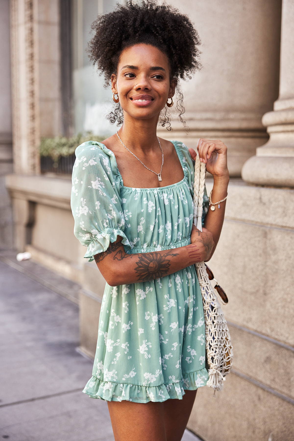 Sage green white floral printed romper on girl in the city.