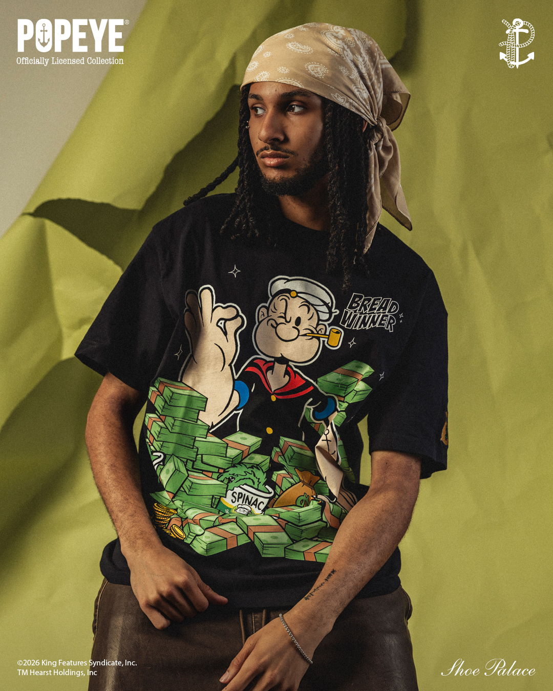 Person wearing a Popeye graphic t-shirt against a green background.