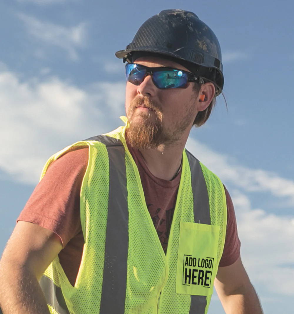 Construction worker wearing hard hat, safety glasses and hi-vis vest with company logo custom printed on pocket.