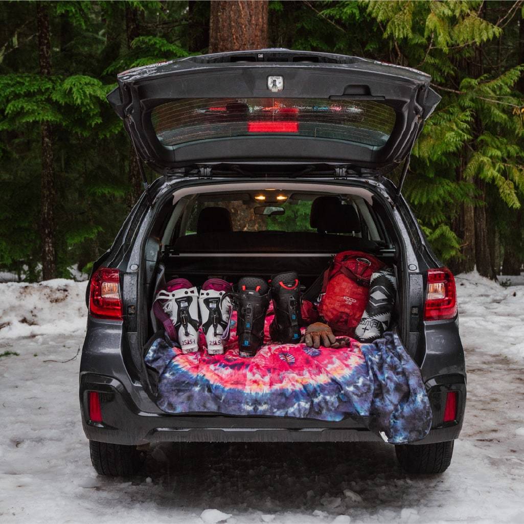 Ski boots in the back of a subaru with a rumpl stash mat