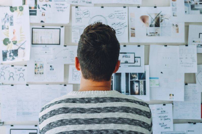 Man looking at board filled with diagrams