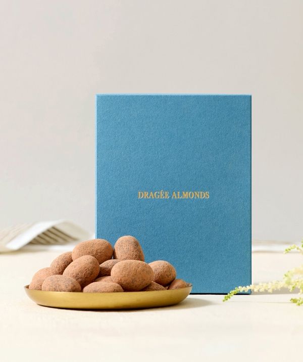 A plate of almonds beside a blue box with gold text.