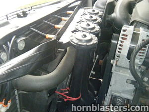 Engine bay view of train horn installation and horn hardware