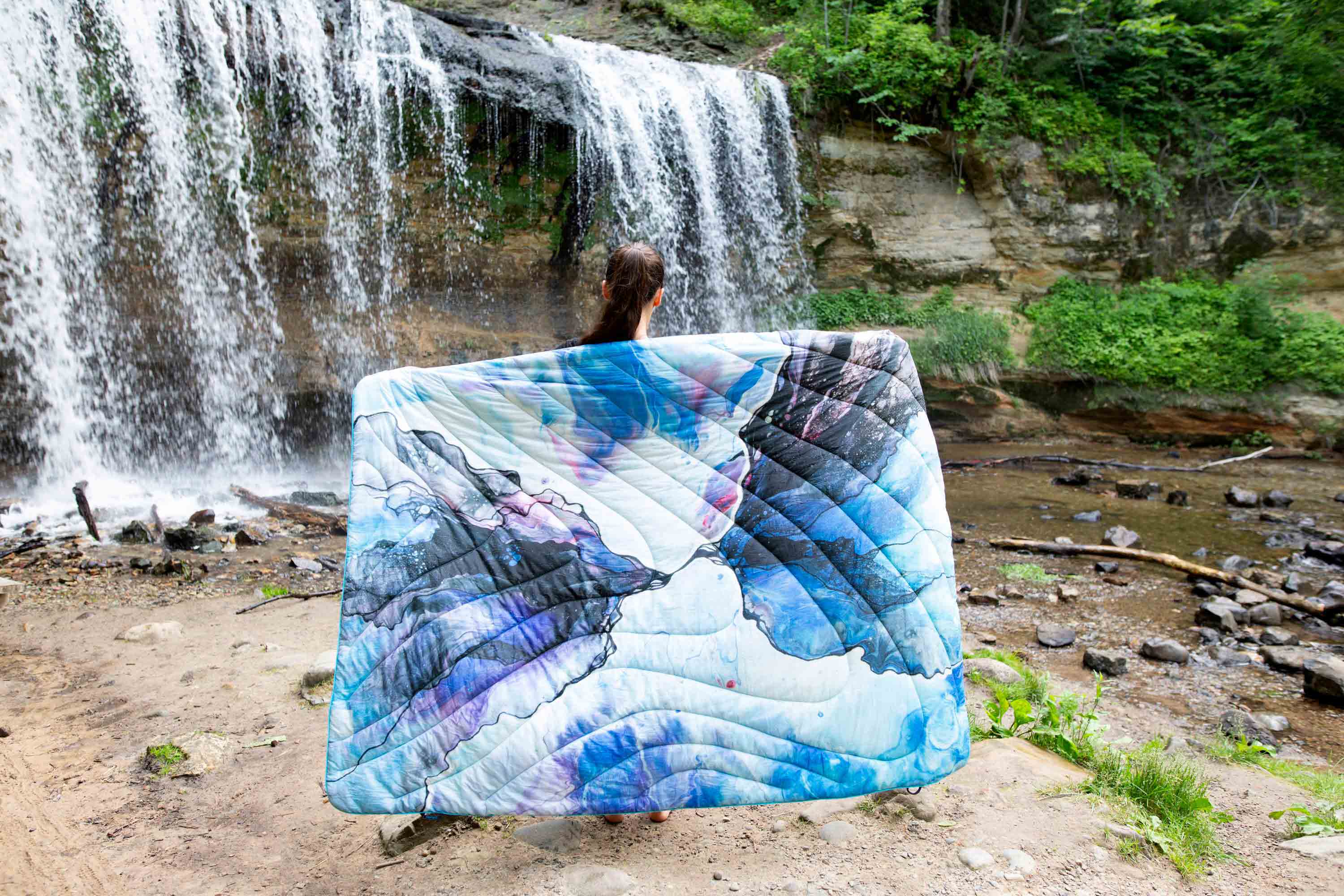 Women standing in front of a waterfall with Rumpl blanket