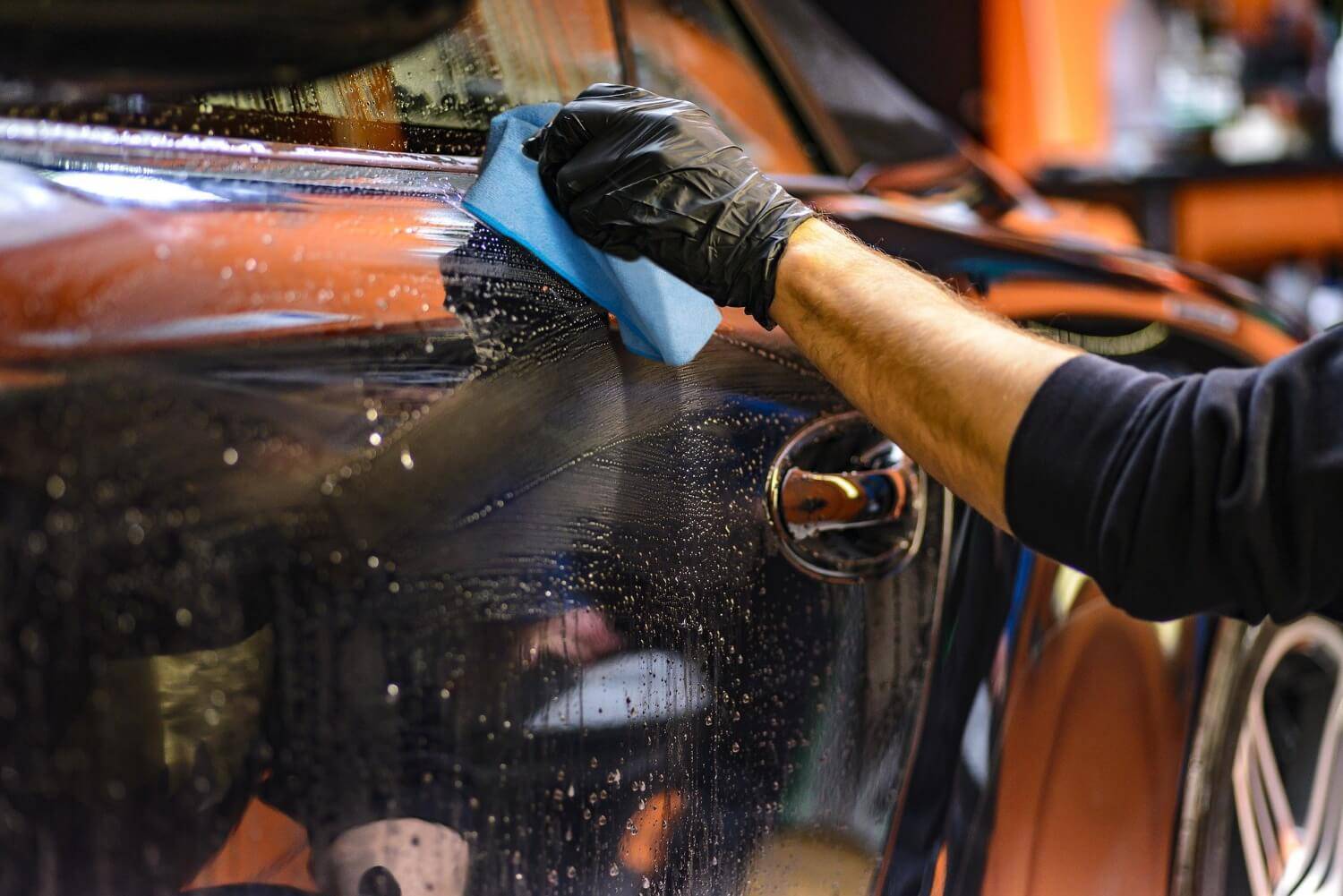 person washing car with microfiber car towel