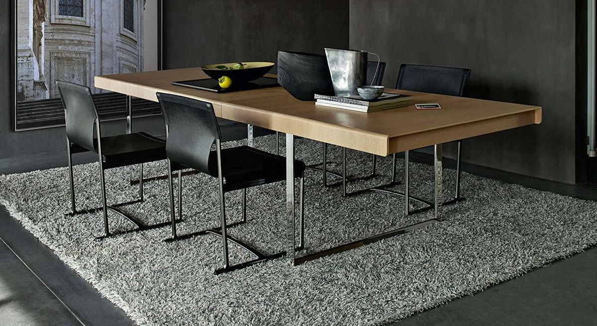 Modern Athos '12 extendable dining table by B&B Italia with black chairs on a textured rug.