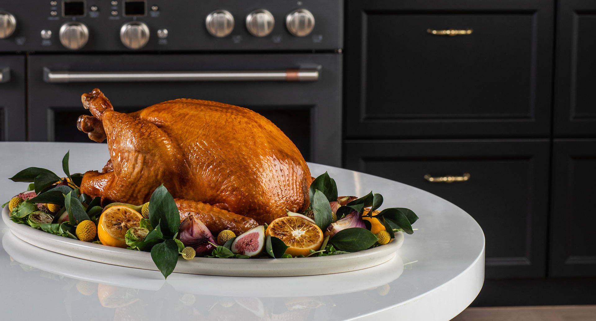Roasted turkey on a dish with lemons, figs and festive greenery