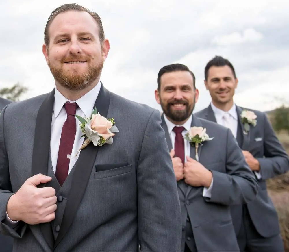 Groomsmen wearing burgundy ties and gray suits