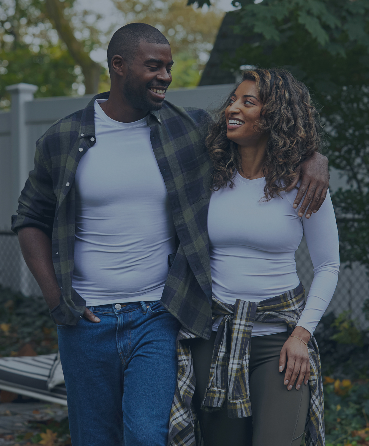 Smiling couple walking together outdoors wearing Tommie Copper Support Shirts.