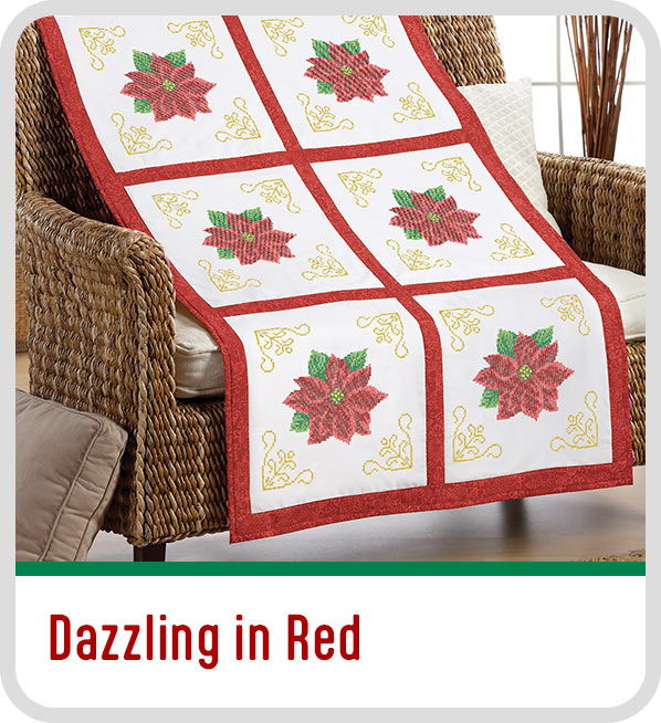 Quilt featuring red flowers on a white background draped over a chair. Dazzling in Red