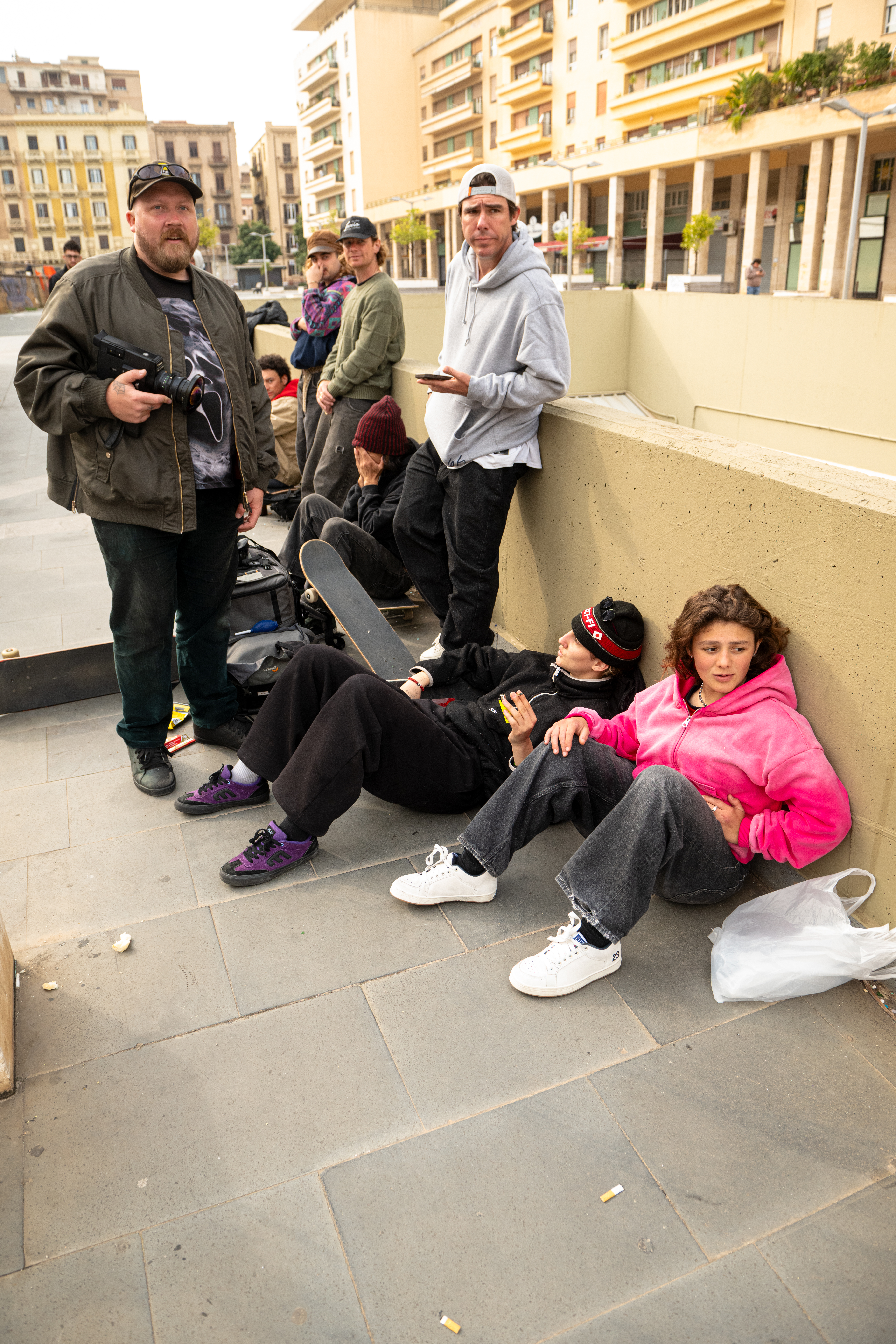 A group of people sitting and standing in an urban environment.