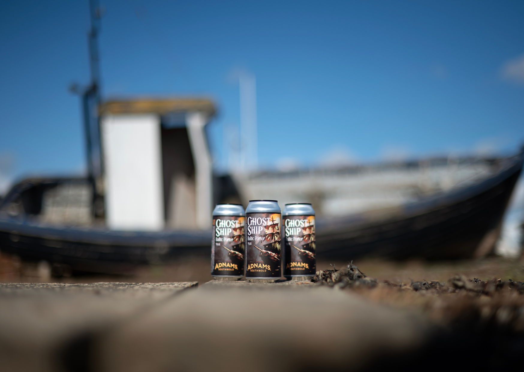 Ghost Ship Baltic Porter cans pictured at Southwold Harbour in front of an old fishing boat.