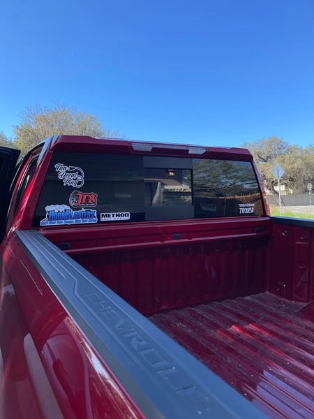 Truck bed and rear window view of Chris's red 2022 Chevrolet Silverado showing decals and clean bed area, install photo 2