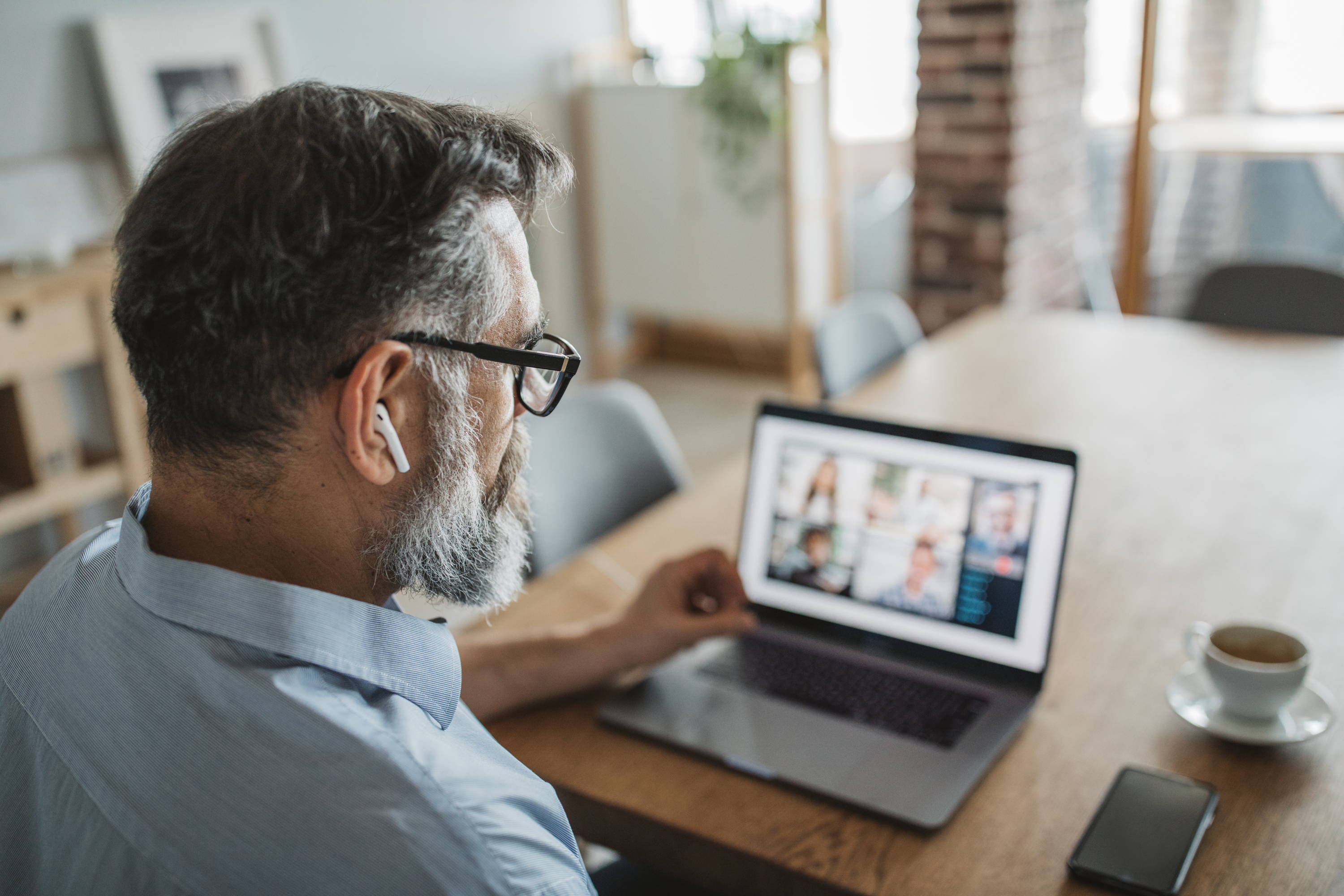 Man with glasses and headphones at laptop