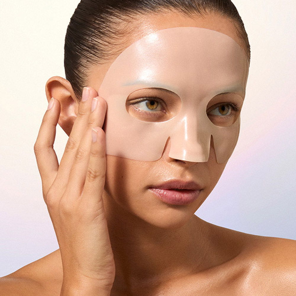 Woman applying a facial mask with a serene expression.