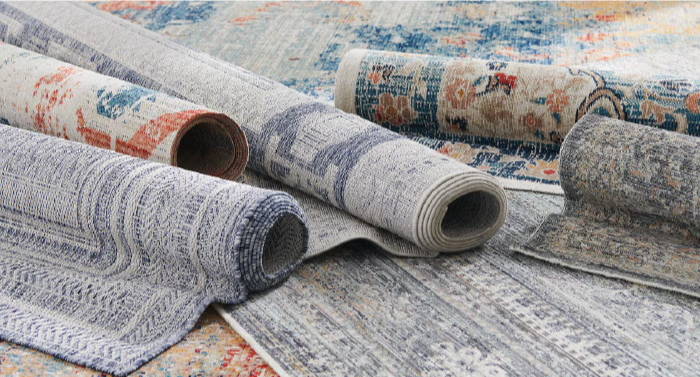 Various rolled-up rugs displayed on a surface.