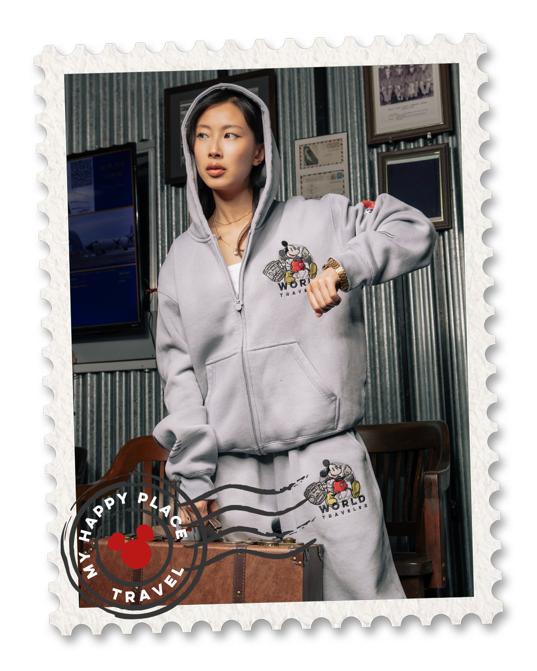 Person wearing a gray hoodie and sweatpants, posing in a vintage setting.