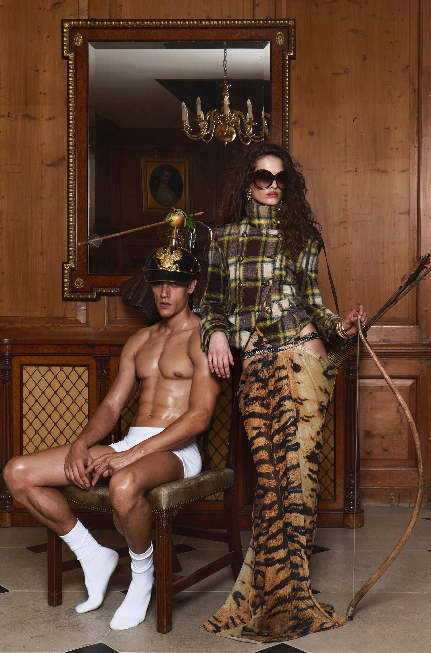 A man in a chair and a woman in a patterned outfit.