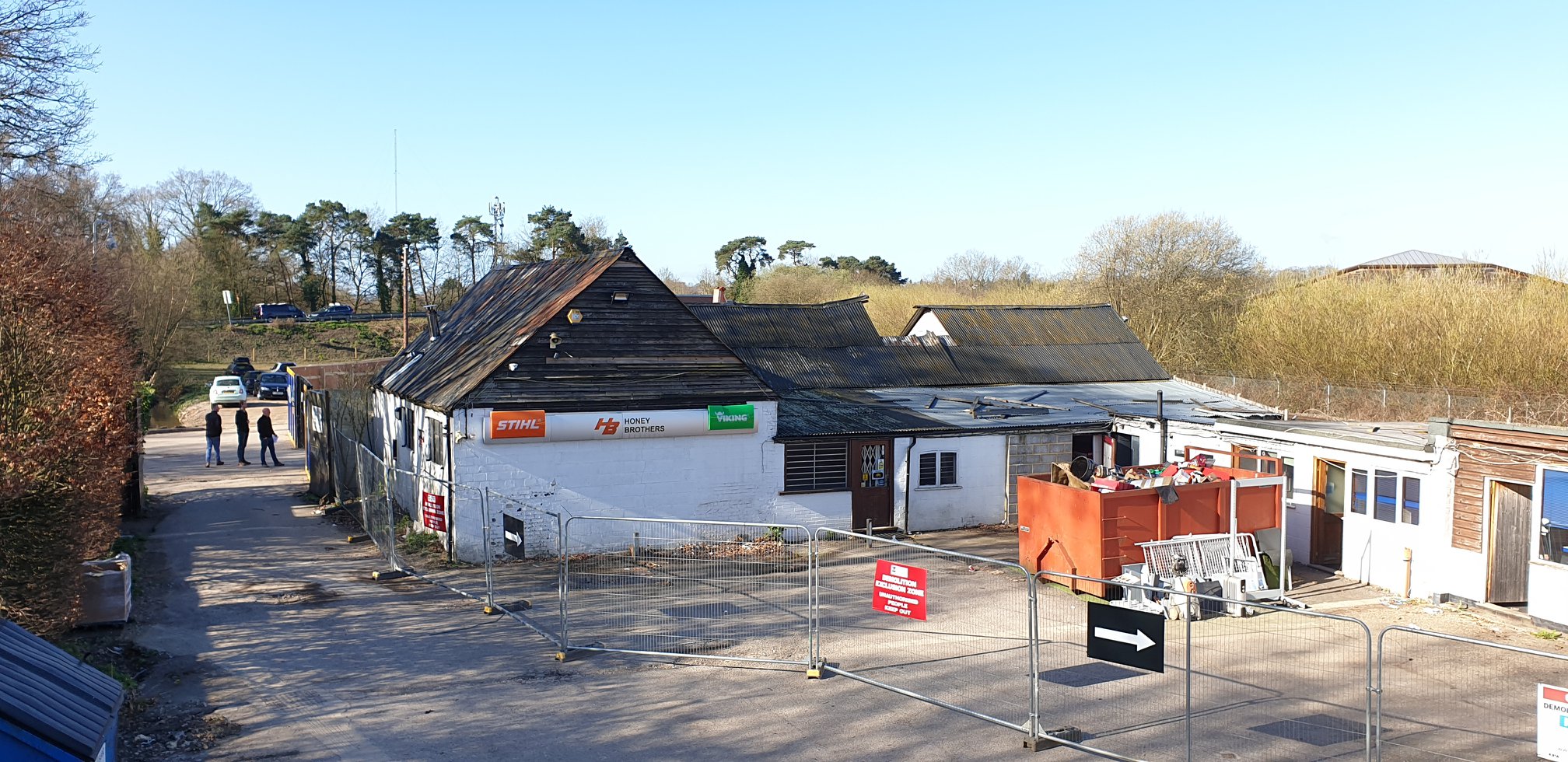 Construction site with buildings and vehicles under clear blue sky.