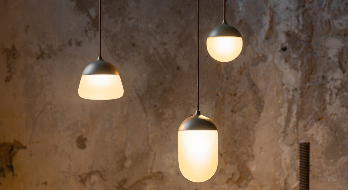 Three pendant lights hanging against a textured wall.