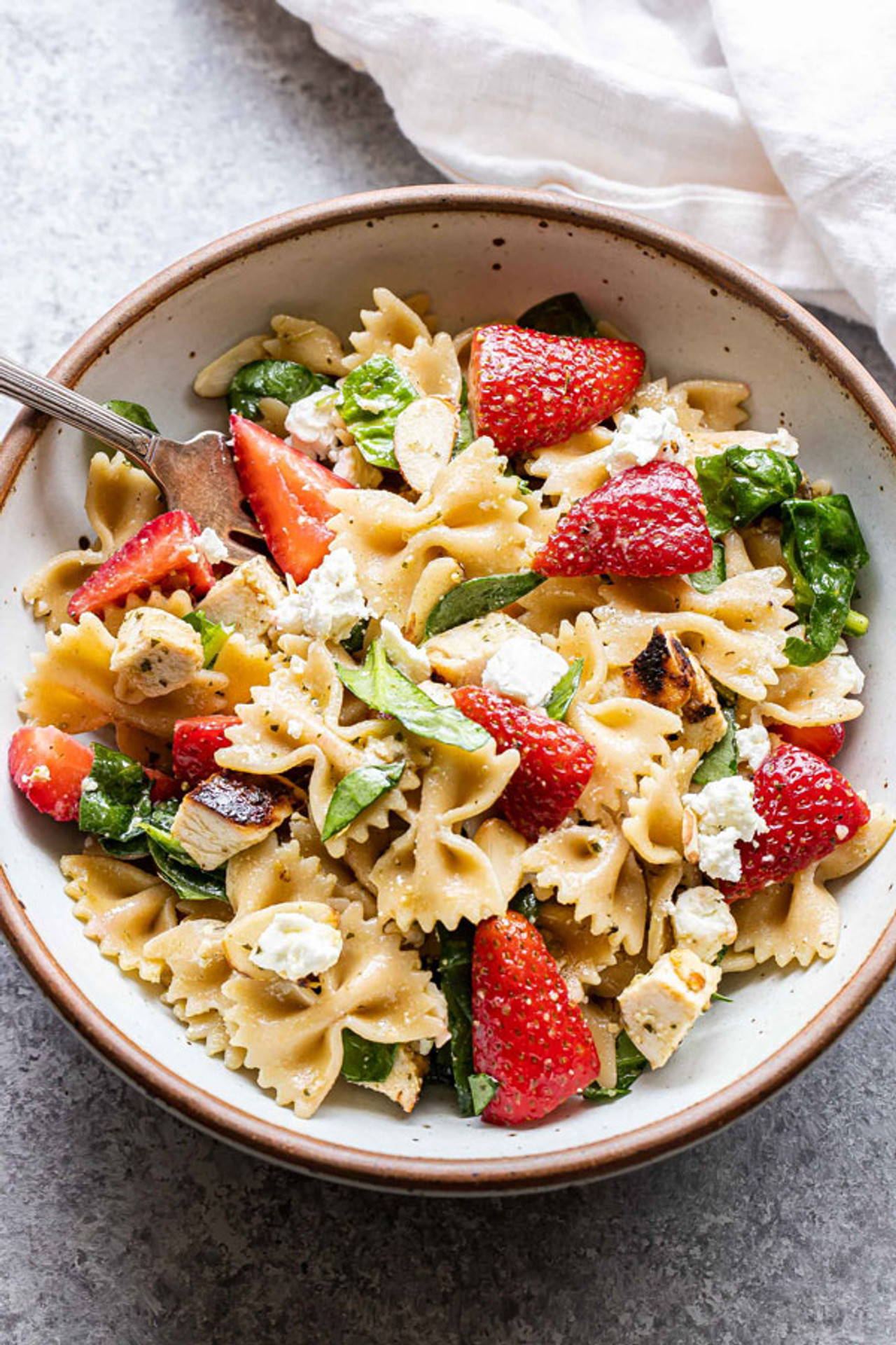 Pasta salad with strawberries, grilled chicken and spinach