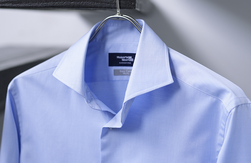 Light blue dress shirt hanging on a hanger with a collar.