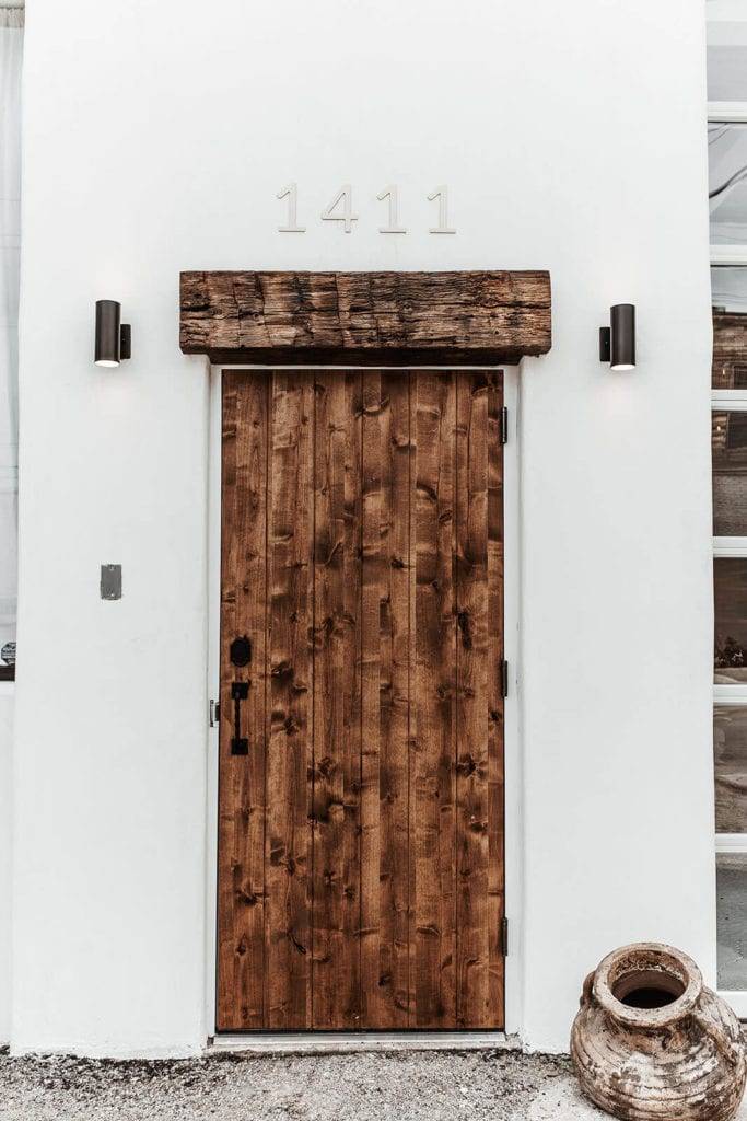 Rustic wooden door on white washed wall outside 1411