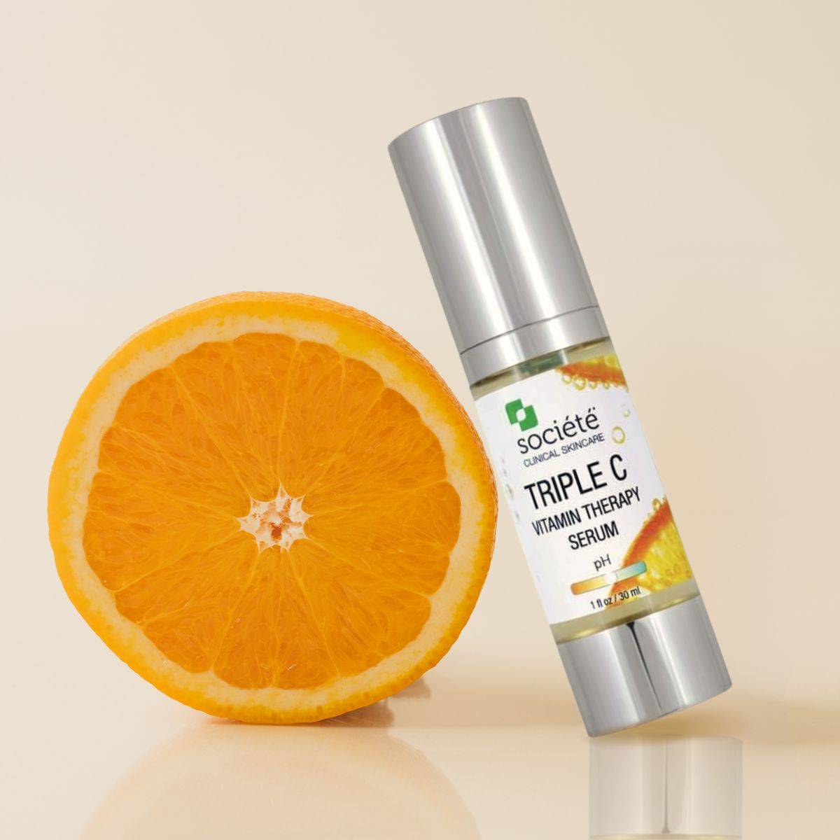 Societe Triple C Vitamin Therapy Serum image laying next to an orange on a beige background