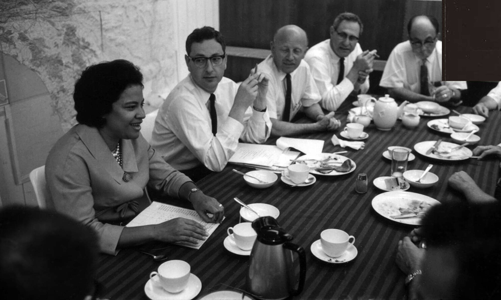 Architect Norma Sklarek, a black woman, sitting in a conference room surrounded by white men